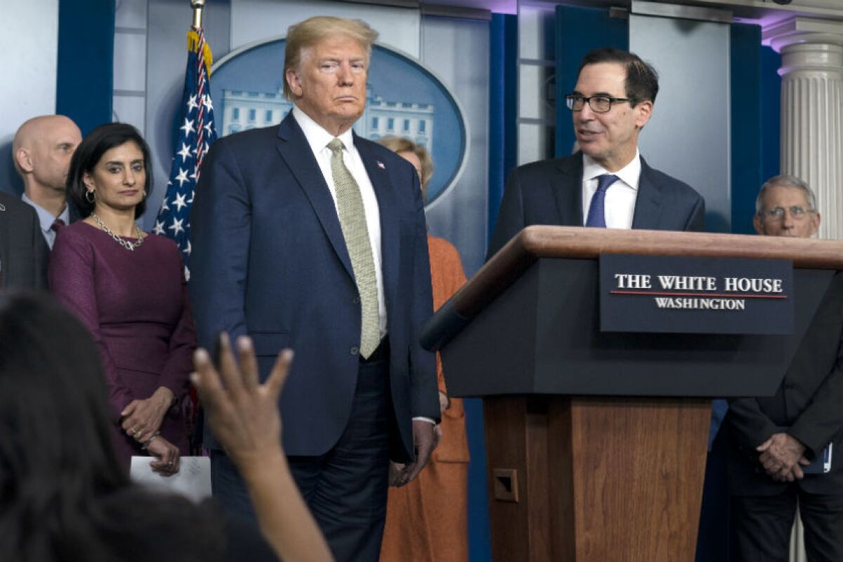 President Trump and Treasury Secretary Steven T. Mnuchin, at lectern, during a news briefing with the coronavirus task force at the White House on Tuesday.
