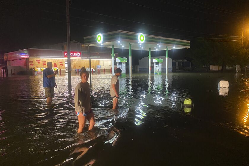 People wade in floodwaters in North Myrtle Beach, S.C., on Monday Night.