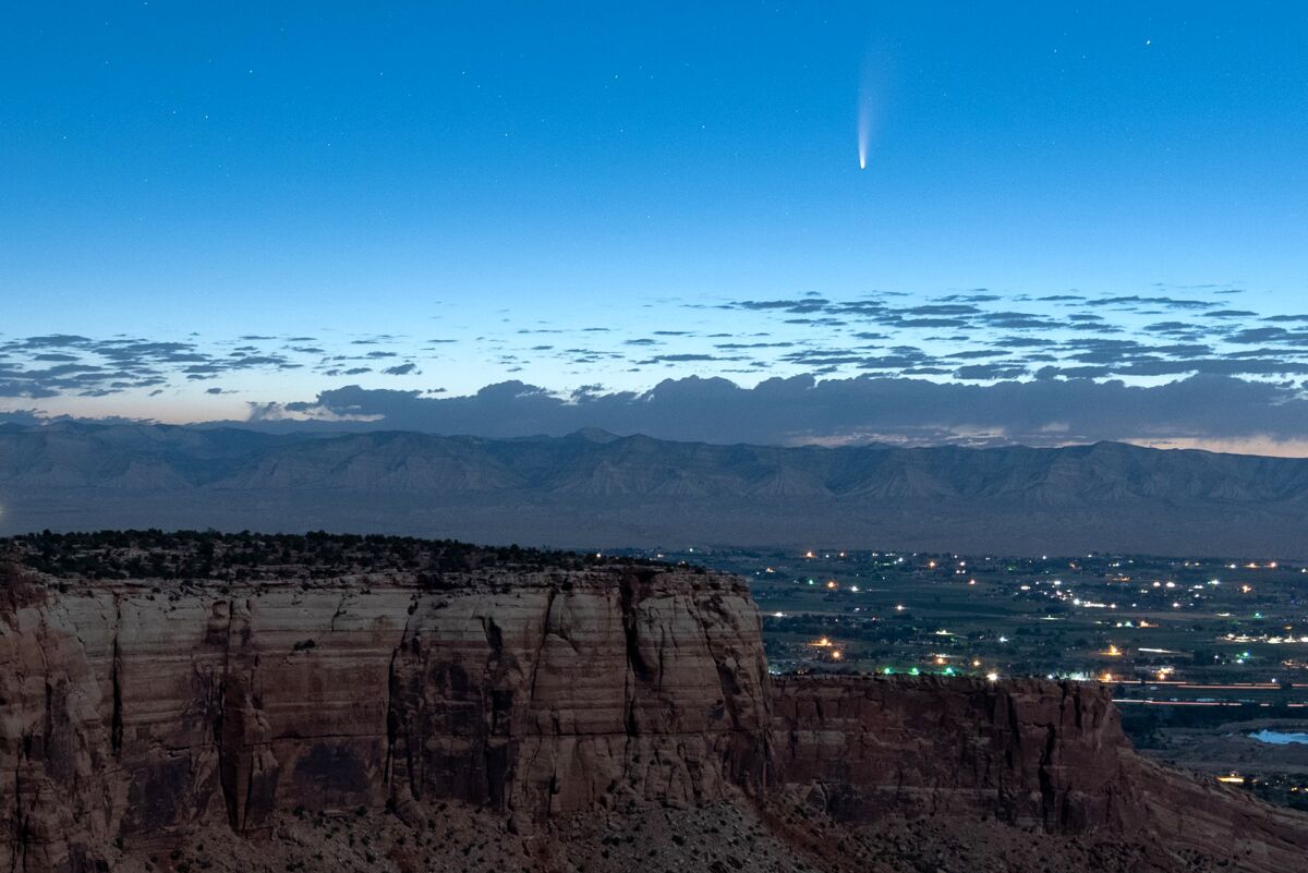 Comet Neowise soars in the horizon of the early morning sky in this view from the near the grand view lookout at the Colorado National Monument west of Grand Junction, Colo., Thursday, July 9, 2020. The newly discovered comet is streaking past Earth, providing a celestial nighttime show after buzzing the sun and expanding its tail. (Conrad Earnest via AP)
