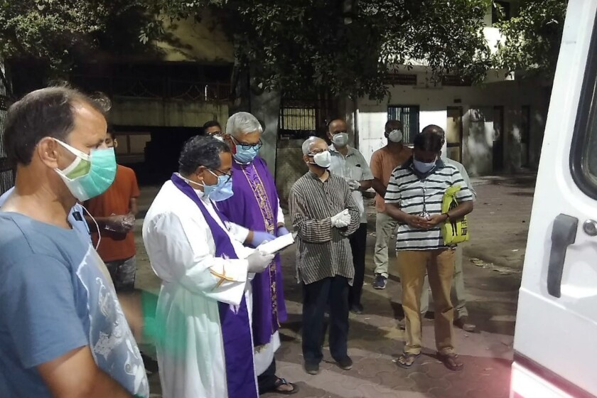 In this April 18, 2021, photo provided by the Rev. Cedric Prakash, priests pray over the body of the late Rev. Jerry Sequeira before his cremation in Ahmedabad, India. Sequeira is one of more than 500 Catholic priests and nuns who have died from COVID-19 in India according to the Rev. Suresh Mathew, a priest at Holy Redeemer's Church in New Delhi and the editor of the church-run Indian Currents magazine. (Cedric Prakash via AP)