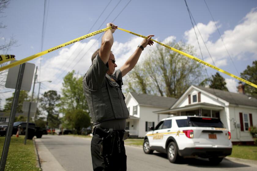 Law enforcement investigate the scene of a shooting, Wednesday, April 21, 2021 in Elizabeth City, N.C. At least one law enforcement officer with a sheriff's department in North Carolina shot and killed a man while executing a search warrant Wednesday, the sheriff's office said. (Stephen M. Katz/The Virginian-Pilot via AP)