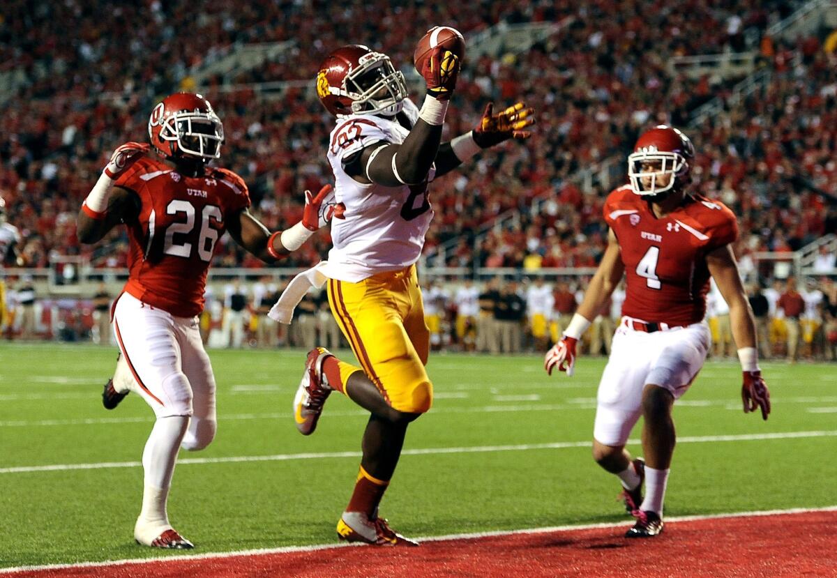 USC tight end Randall Telfer makes a one-handed catch for a touchdown in front of Utah defenders Ryan Lacy and Brian Blechen during a game last season.