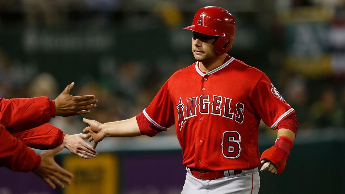 David Fletcher celebrates with his Angels teammates after scoring on a sacrifice fly by Mike Trout (not pictured) during the eighth inning of a game against the Oakland Athletics on March 30.