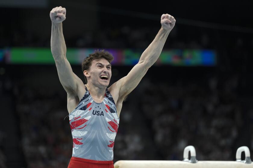 Olympian Stephen Nedoroscik in his team USA gymnastics uniform cheering with both his hands in the air 