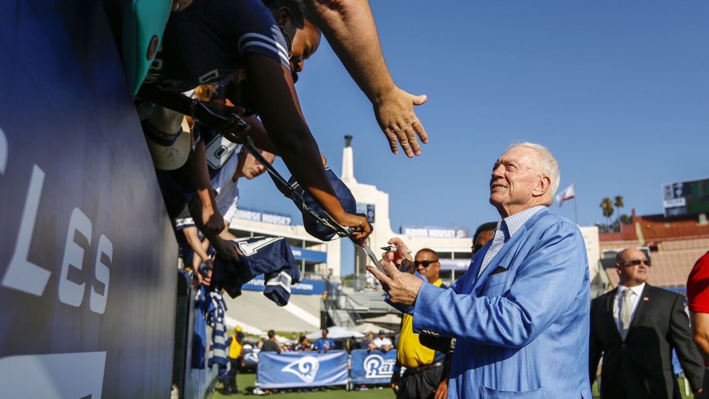 Dallas Cowboys owner Jerry Jones signs autographs for fans before a preseason game against the Rams at the Coliseum.