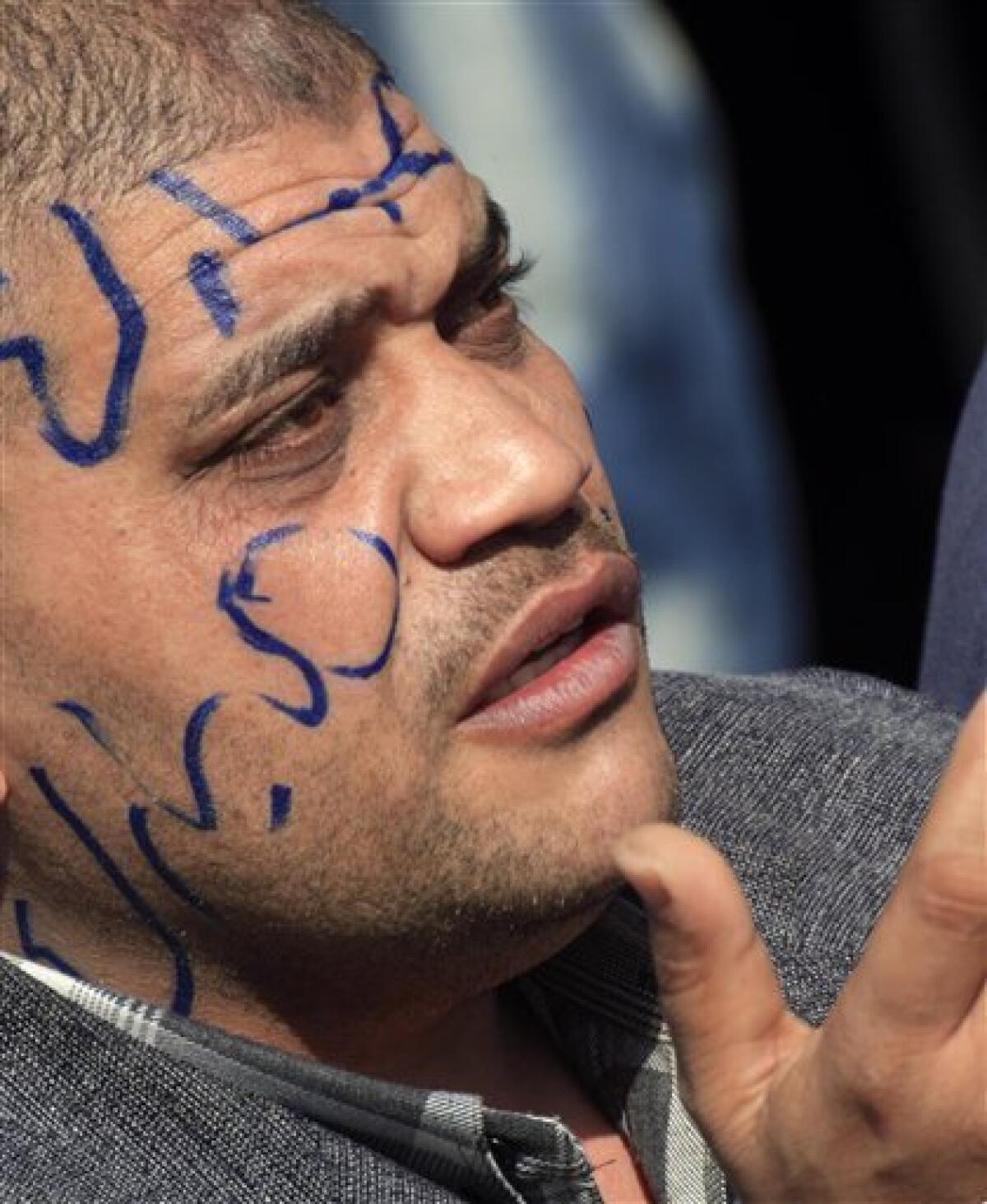 An Egyptian pro-Mubarak supporter with "Mubarak" written on his face prays during march in Cairo, Egypt, Tuesday, Feb. 1, 2011. Egyptian authorities battled to save President Hosni Mubarak's regime with a series of concessions and promises to protesters, but realities on the streets of Cairo may be outrunning his capacity for change. (AP Photo/Amr Nabil)