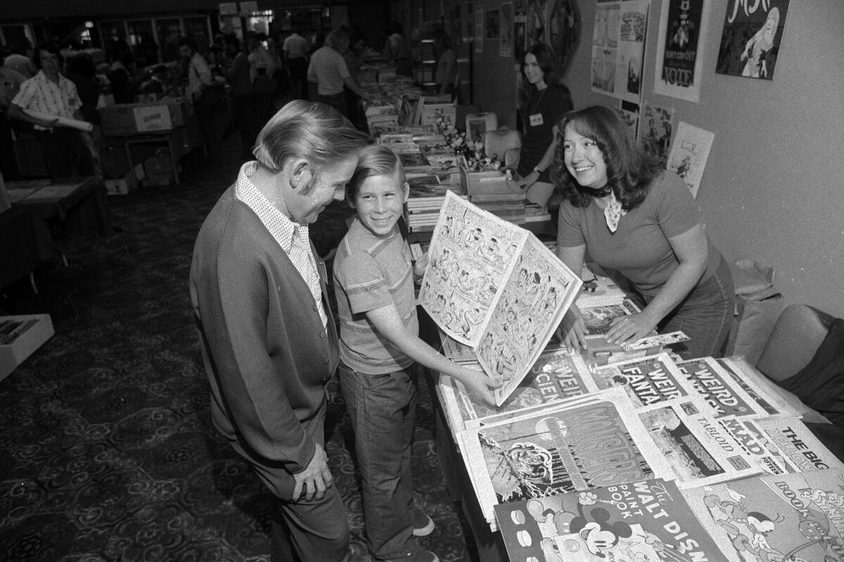 Dr. Curtis W. Fisher and his son, John, get a look and a laugh from one of the comic books at the San Diego Comic-Con in the El Cortez Hotel in 1975.