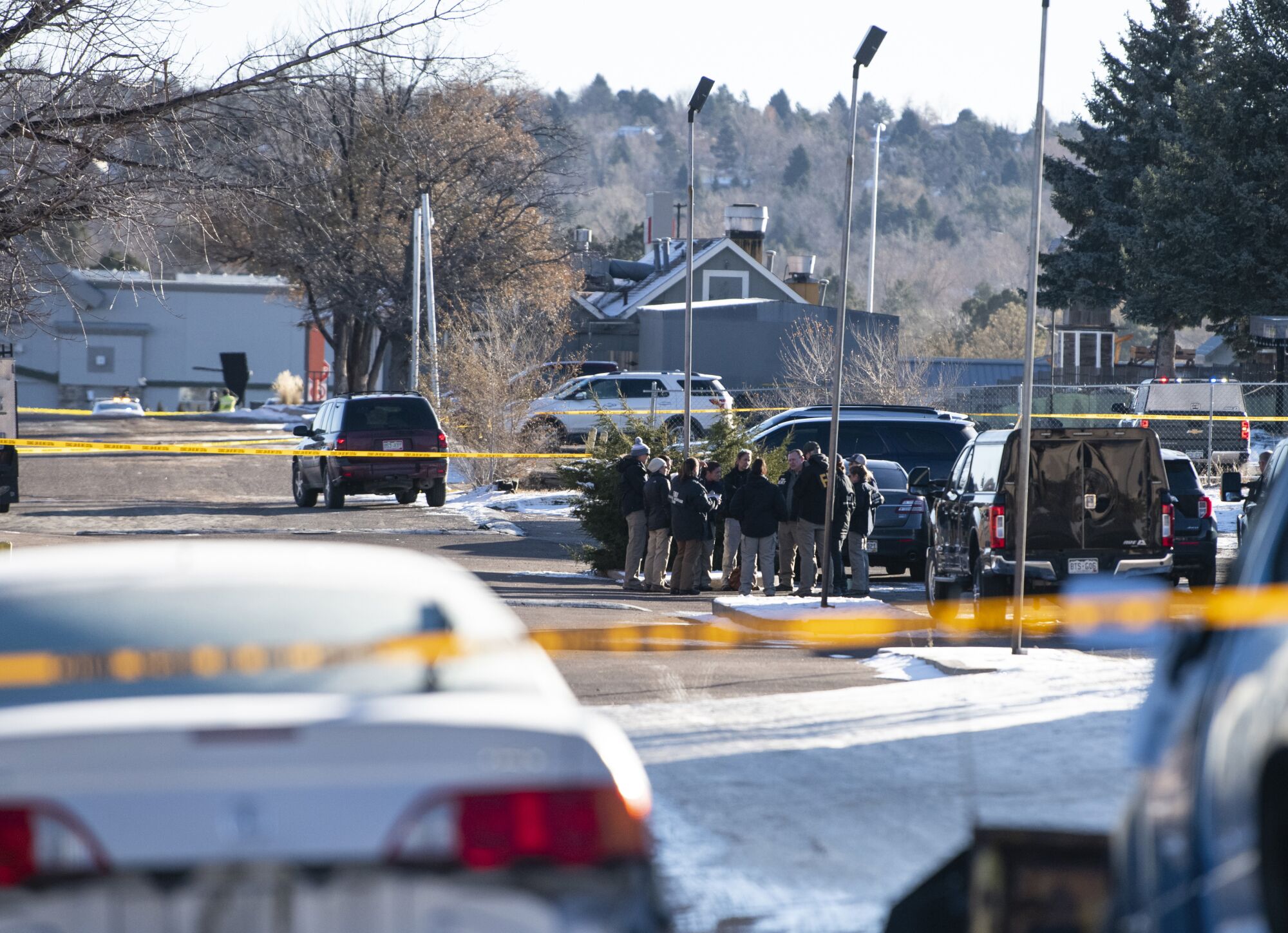 Law enforcement personnel stand outside of the scene of a mass shooting at Club Q in Colorado Springs, Colo.