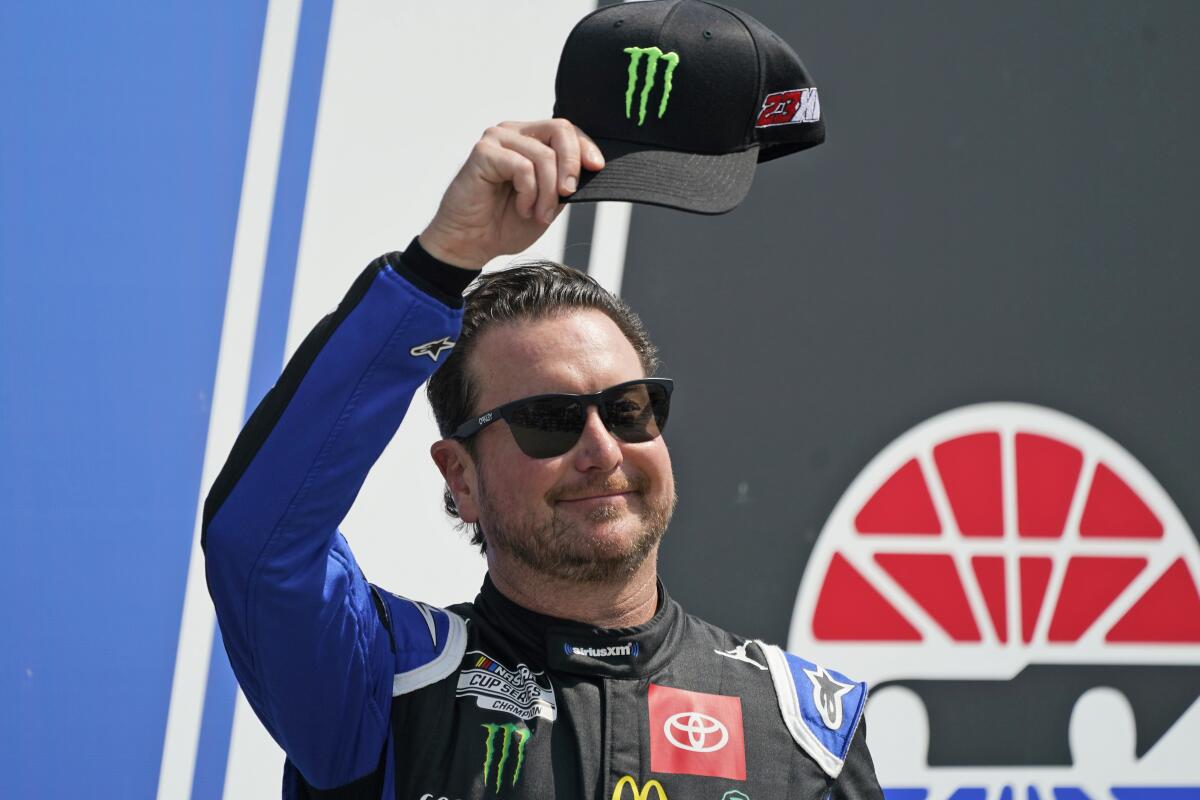 NASCAR Cup Series driver Kurt Busch tips his cap to fans.