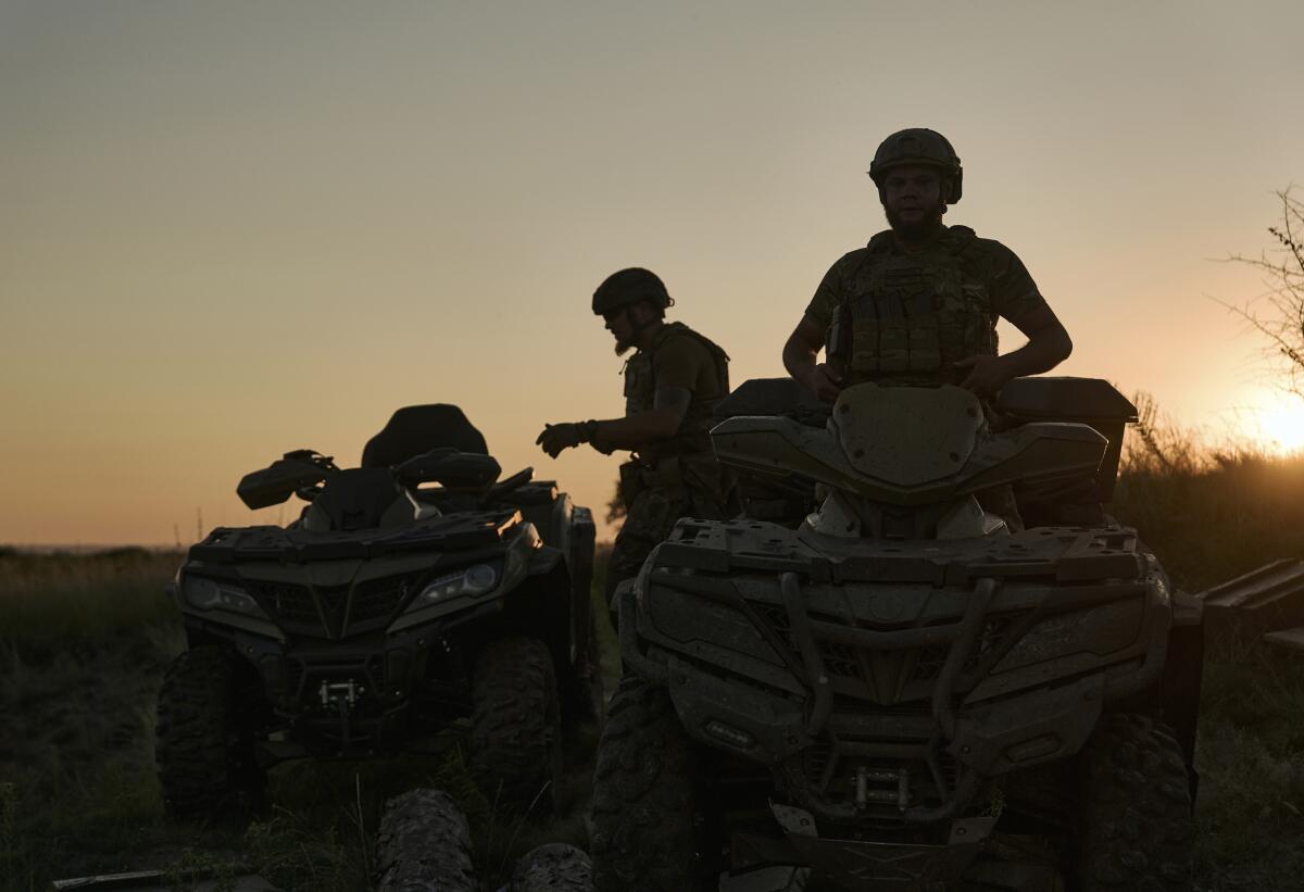 Silhouettes of Ukrainian soldiers riding all-terrain vehicles