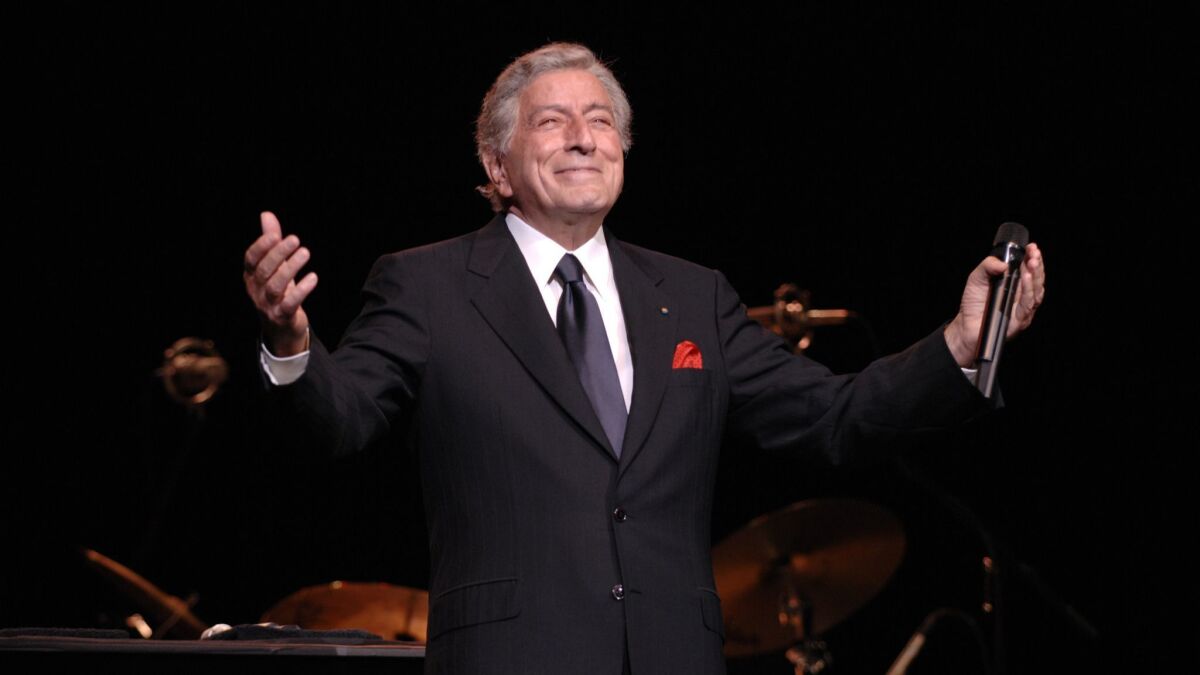 Tony Bennett outstretches his arms onstage.