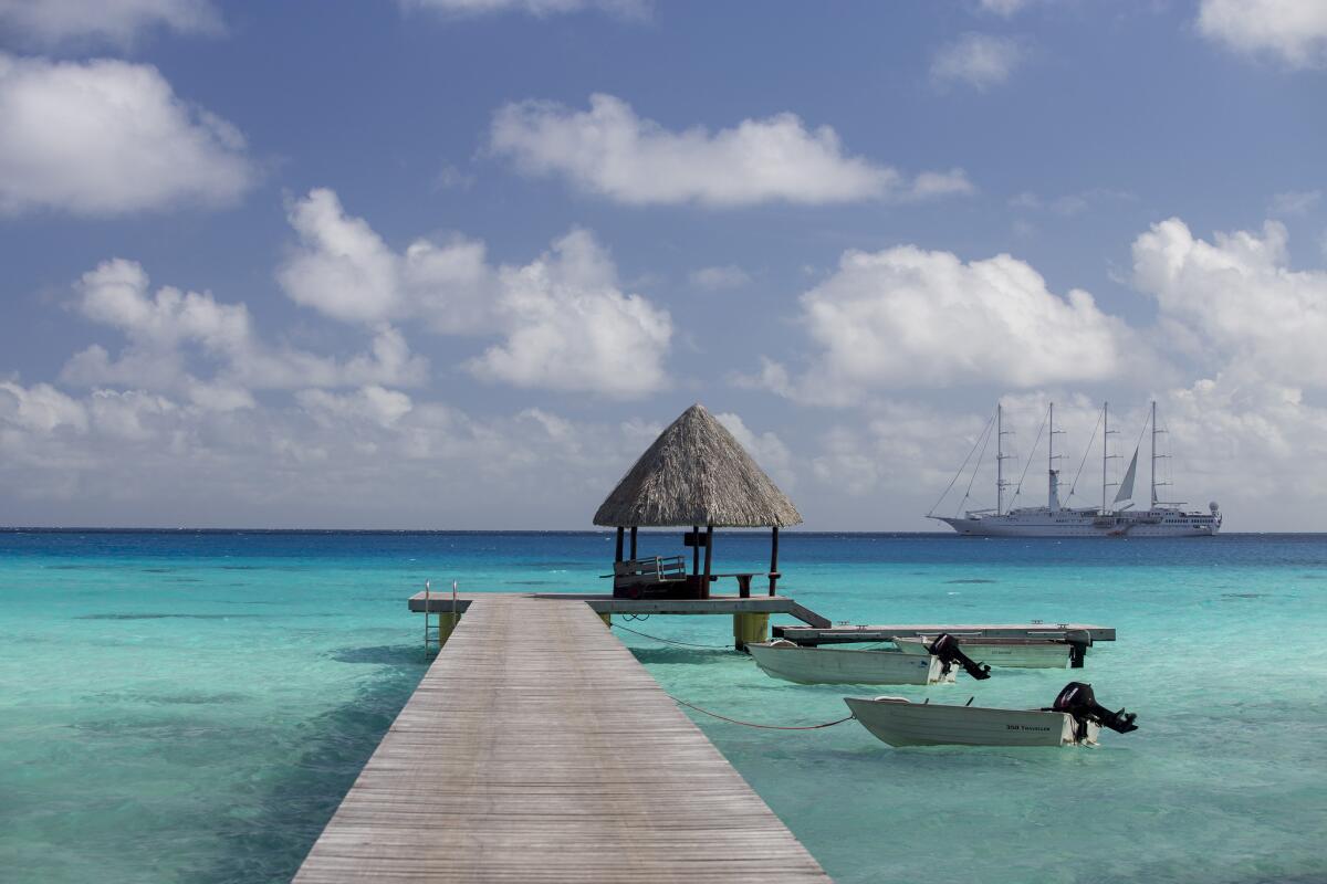 The private dock at Hotel Kia Ora Resort & Spa, French Polynesia. A ship from Windstar Cruises is seen in the distance.