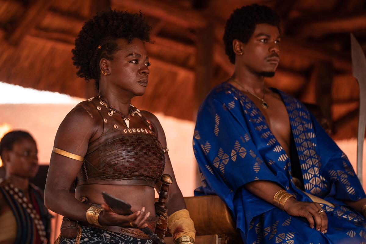 A seated woman and man in African-style costumes.