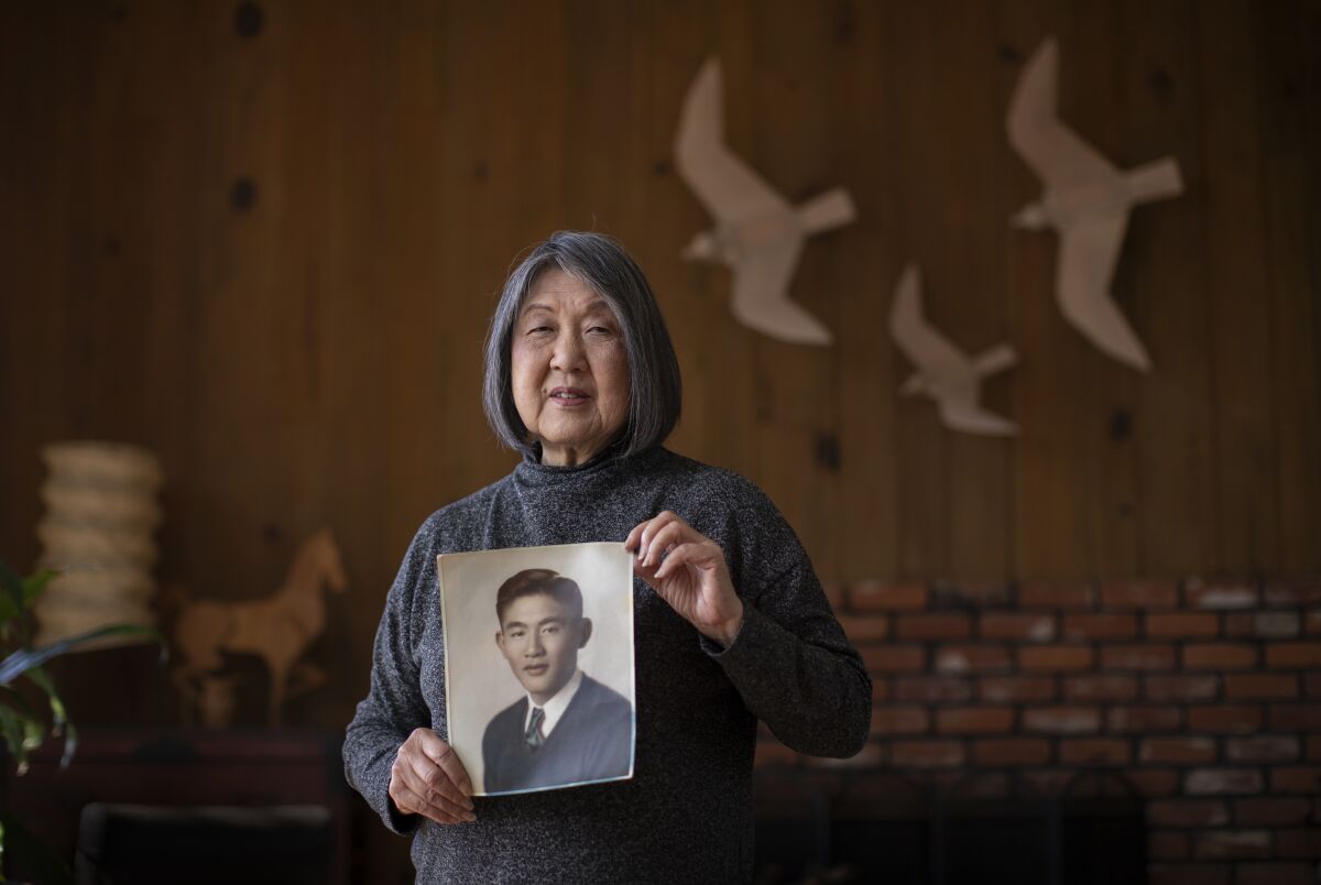 Joanne Kumamoto holds a photo of her father, Jiro Oishi.