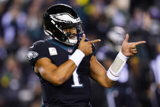 Philadelphia Eagles quarterback Jalen Hurts points with both hands as he celebrates a touchdown run by Kenneth Gainwell 