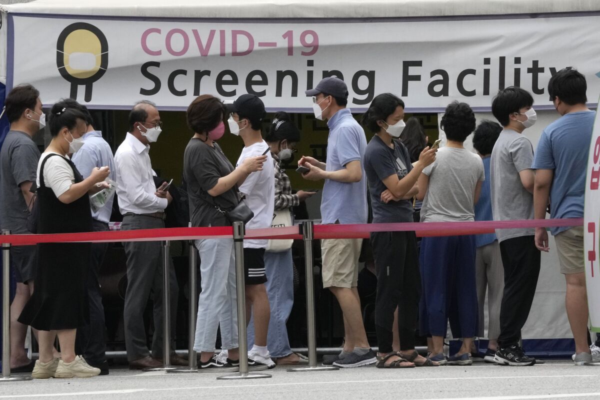 People queue in line to wait for the coronavirus testing at a Public Health Center in Seoul, South Korea, Friday, July 9, 2021. South Korea will enforce its strongest social distancing restrictions in the greater capital area starting next week as it wrestles with what appears to be the worst wave of the coronavirus since the start of the pandemic. (AP Photo/Ahn Young-joon)