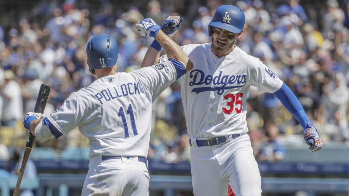 Cody Bellinger, right, celebrates with teammate A.J. Pollock after hitting a home run in the third inning of the Dodgers' 8-7 victory over the Arizona Diamondbacks on Sunday.