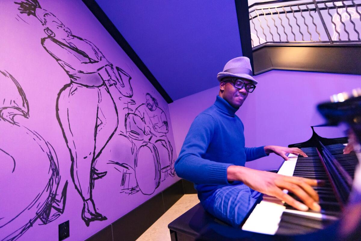A pianist performs in a hotel nook featuring art form Pixar's "Soul."