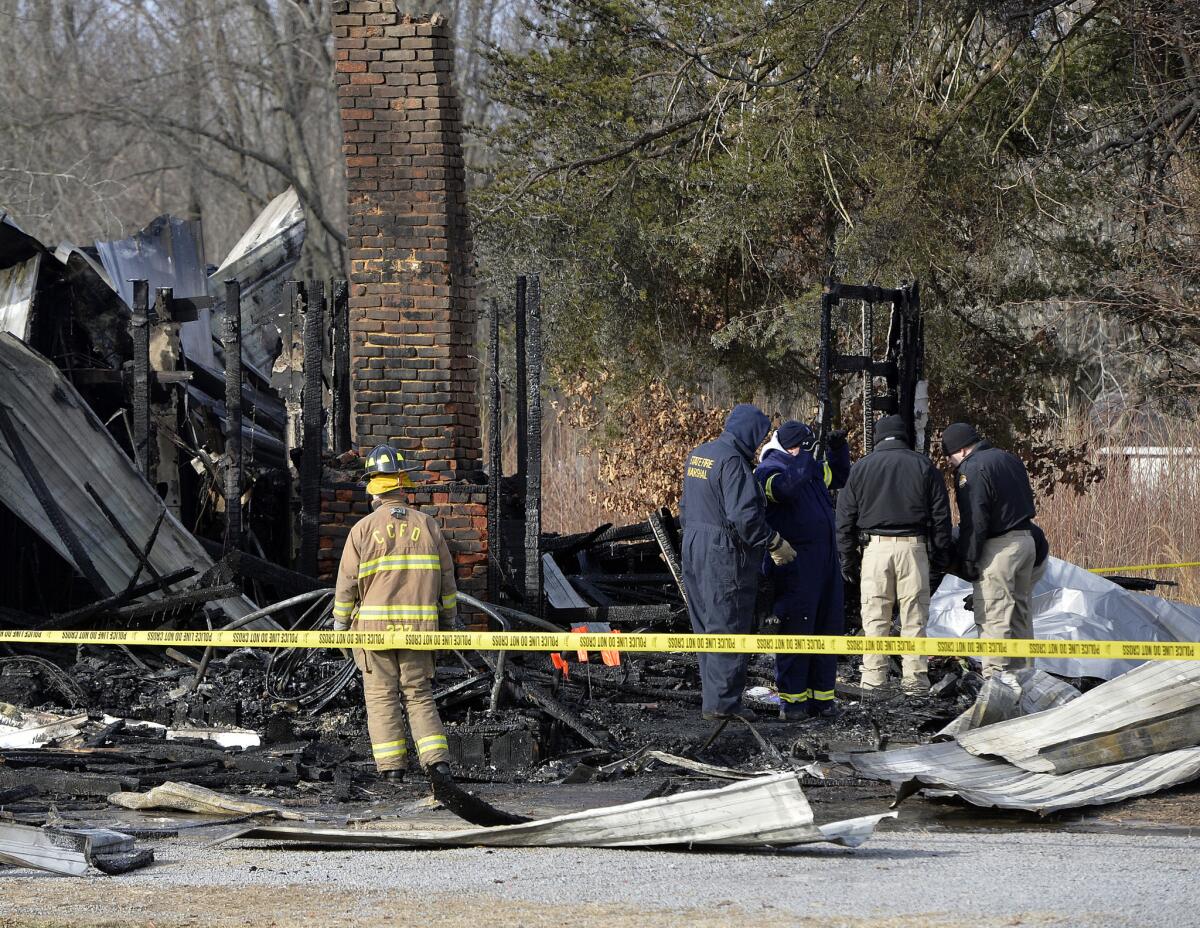 Kentucky State Fire investigators work at the scene of the early morning house fire in Depoy, Ky. The blaze claimed nine lives and left two people injured.