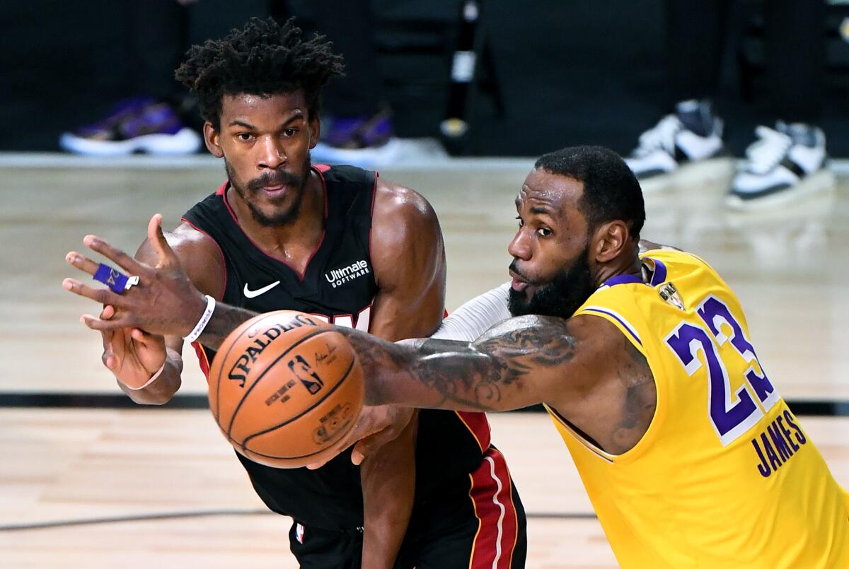 Lakers forward LeBron James tries to break up a pass from Miami Heat forward Jimmy Butler during the fourth quarter.