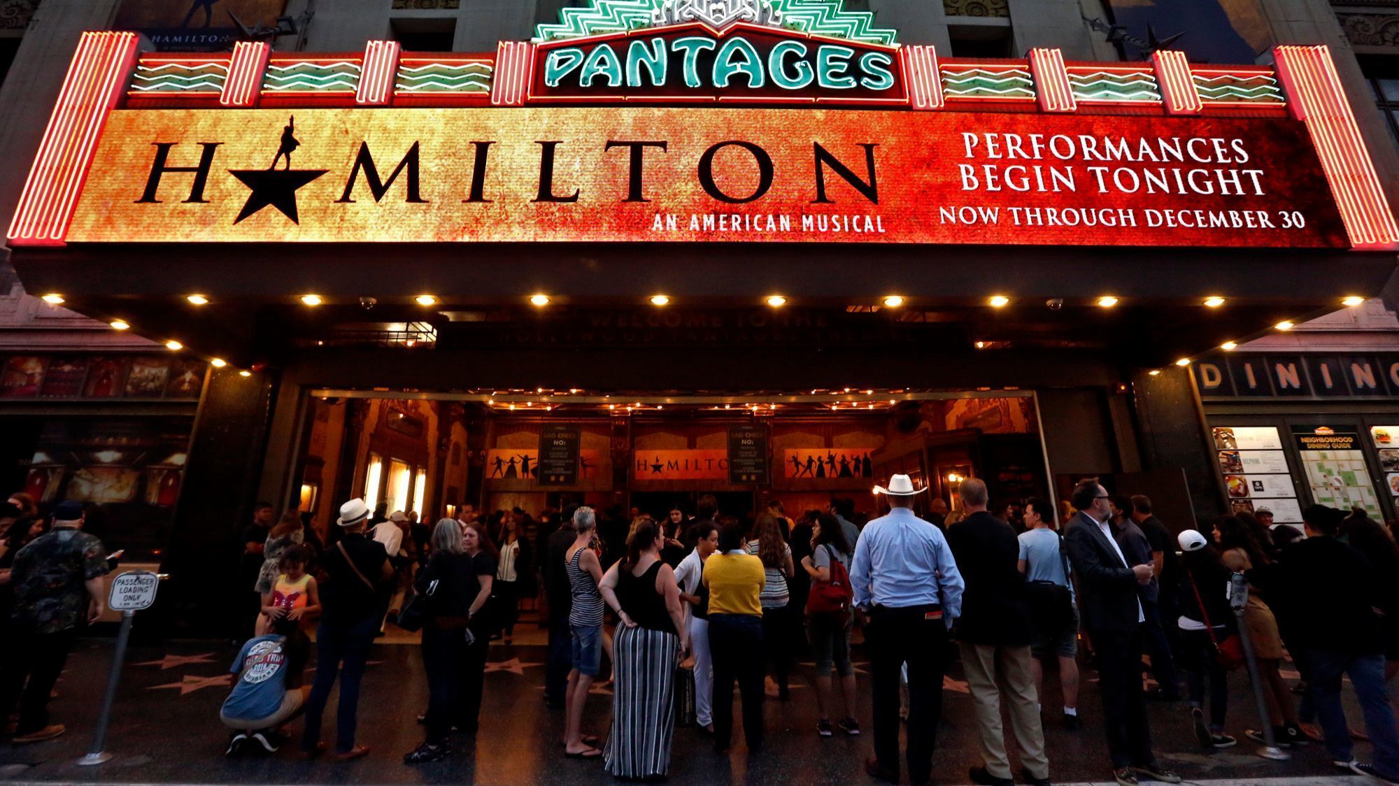 People stand outside the Pantages Theatre 