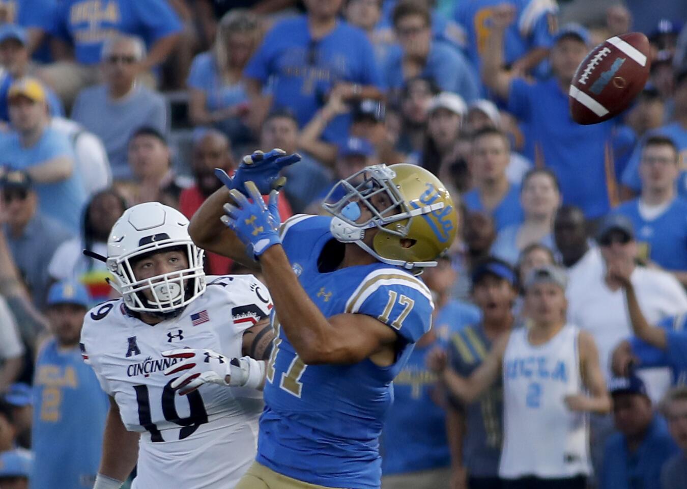 UCLA wide receiver Christian Pabico can't find the handle on a pass as Cincinnati's Ethan Tucky defends in the third quarter at the Rose Bowl in Pasadena on Saturday.