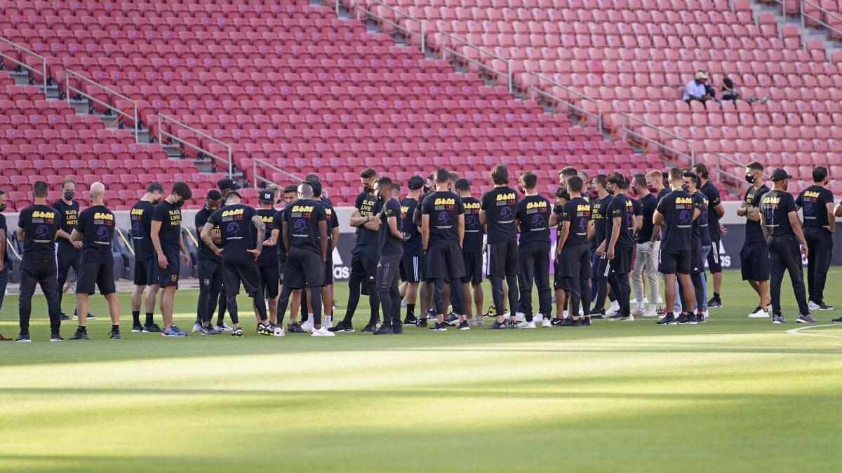 Players and staff gather on the field before the scheduled game between Real Salt Lake and LAFC.