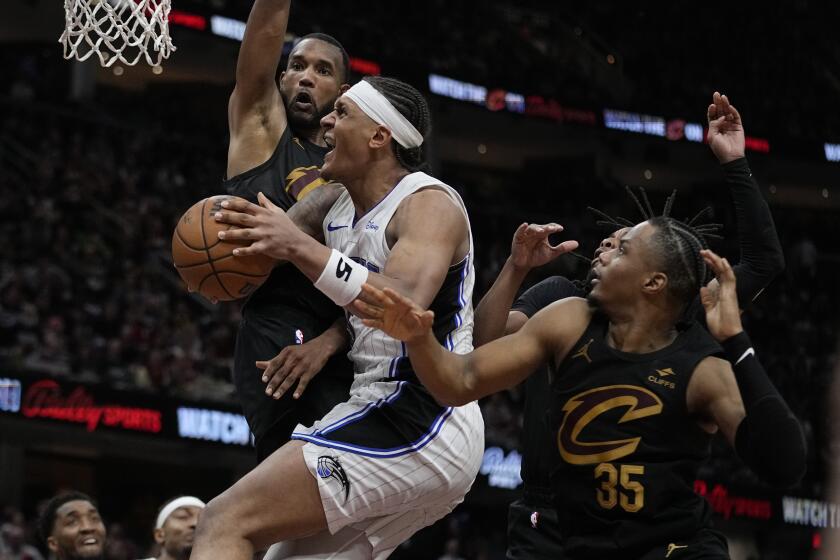 Orlando Magic forward Paolo Banchero, center, drives to the basket between Cleveland Cavaliers forward Evan Mobley, left, ad Isaac Okoro (35) in the second half of Game 7 of an NBA basketball first-round playoff series, Sunday, May 5, 2024, in Cleveland. (AP Photo/Sue Ogrocki)