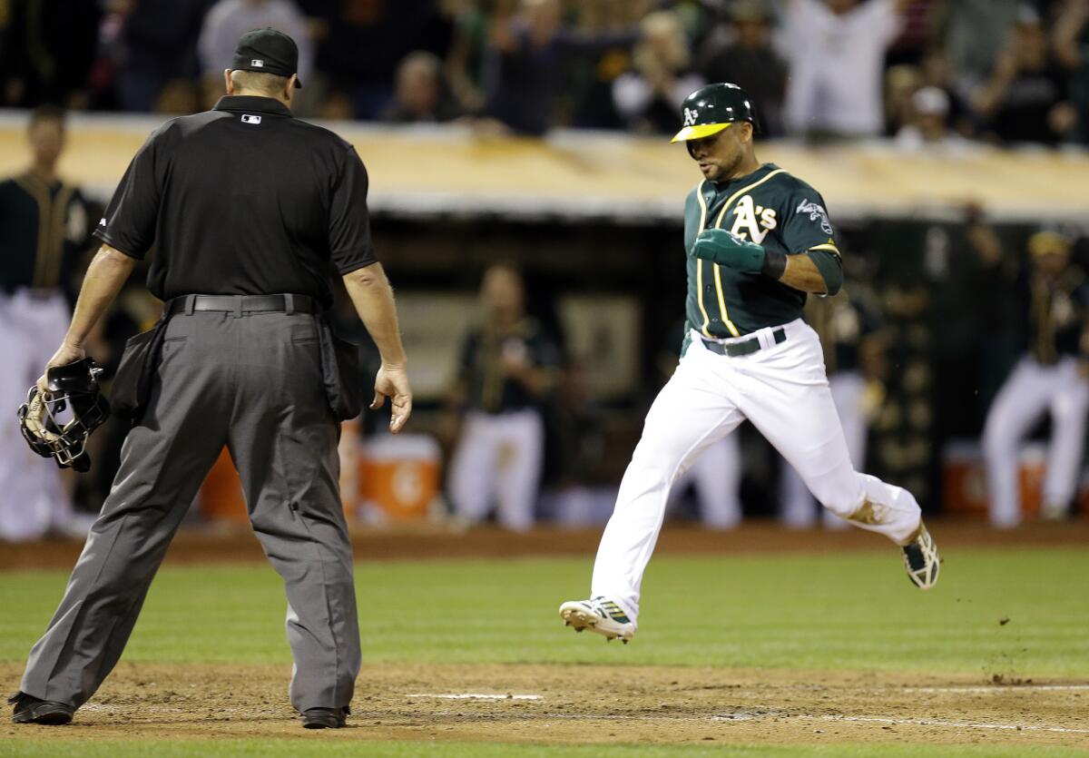Oakland's Coco Crisp scores the eventual winning run on a wild pitch thrown by the Angels' Joe Smith in the eighth inning on Saturday night.