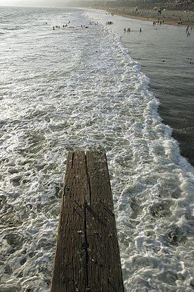 A piece of wood juts out over the ocean along the Santa Monica Pier.