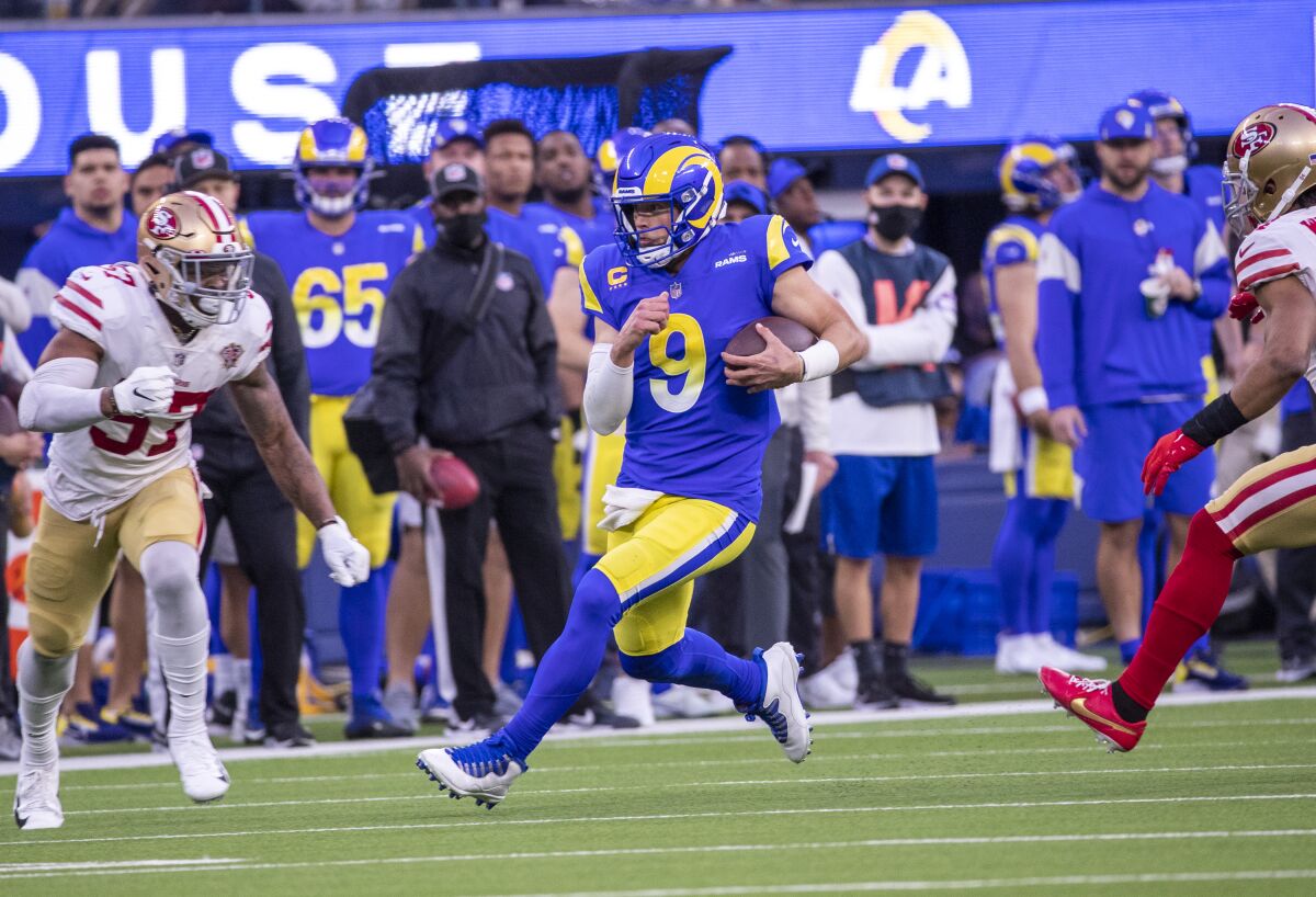 Rams quarterback Matthew Stafford is chased by the 49ers' Dre Greenlaw, left, and K'Waun Williams.