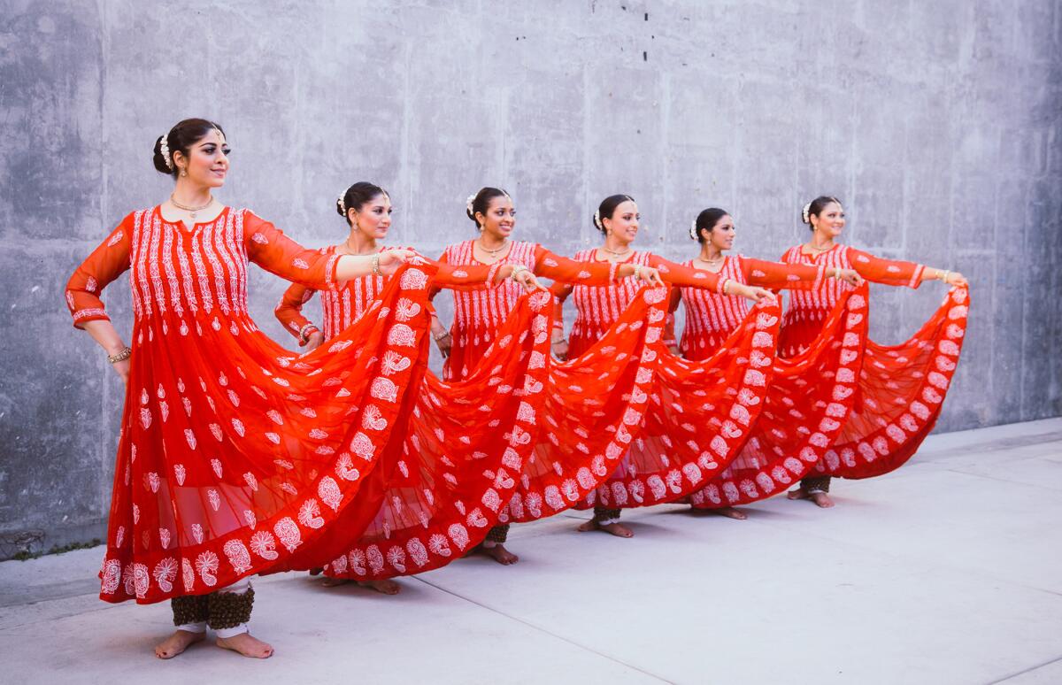 Six dancers in flowing red dresses