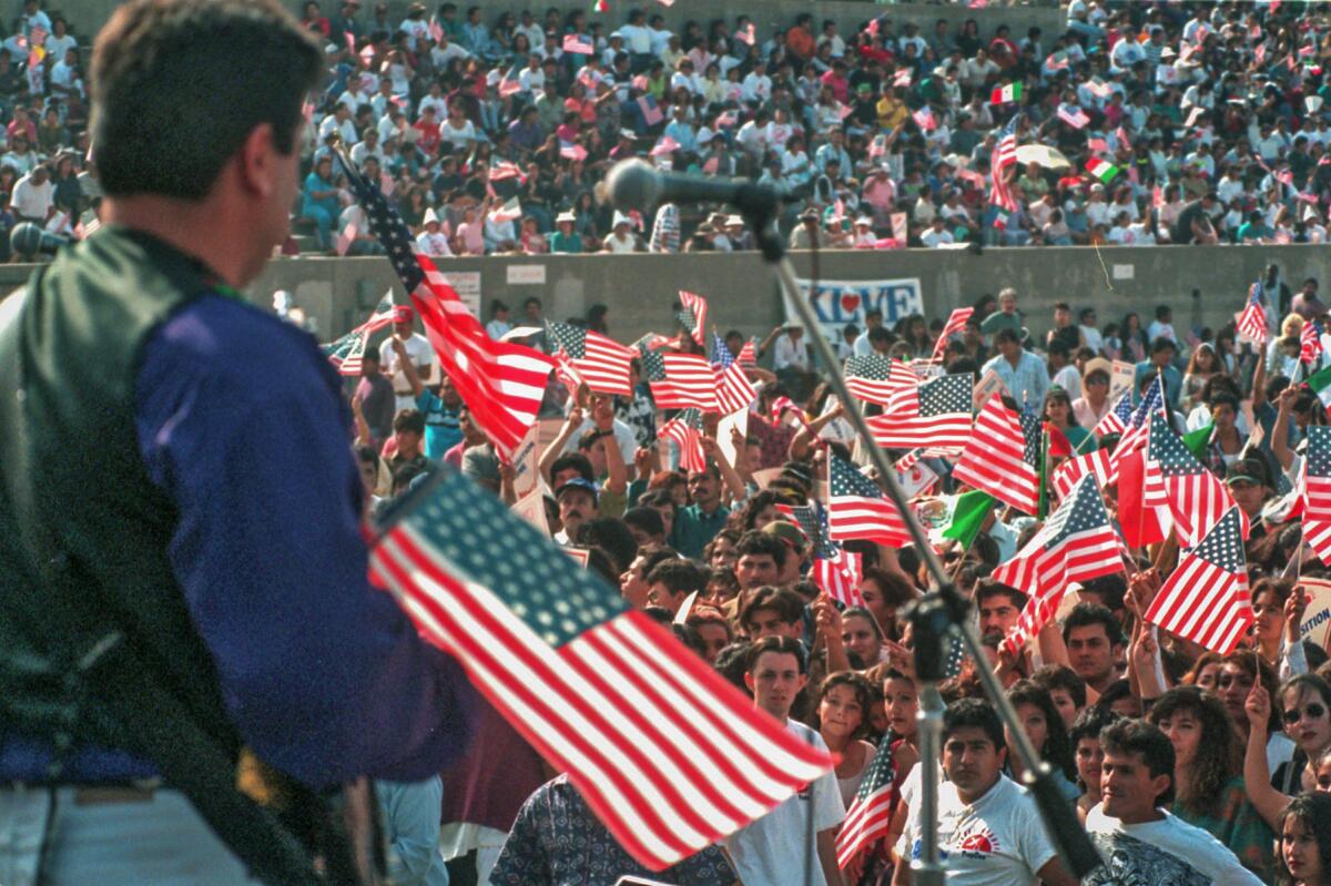 Oct. 30, 1994: Thousands of people gathered at East Los Angeles College's Weingart Stadium for a concert and political rally to oppose Proposition 187 and acknowledge political candidates who also oppose the controversial proposition. American flags are waved after criticism of Mexican flags being used at previous protests.