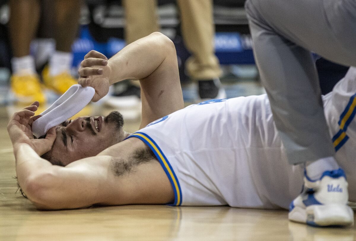 UCLA guard Jaime Jaquez Jr. grimaces after coming down hard on the floor.