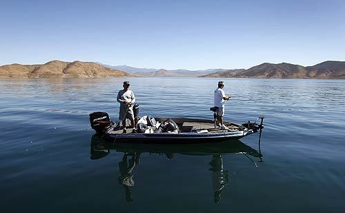 Dan Moreno, right, of Moreno Valley and D.J. Ciletti of Palm Springs take advantage of the final days they can fish from their boat at Diamond Valley Lake in Riverside County. With the water level down to only 60% of capacity, the Metropolitan Water District of Southern California plans to close the 11-lane boat ramp Monday.
