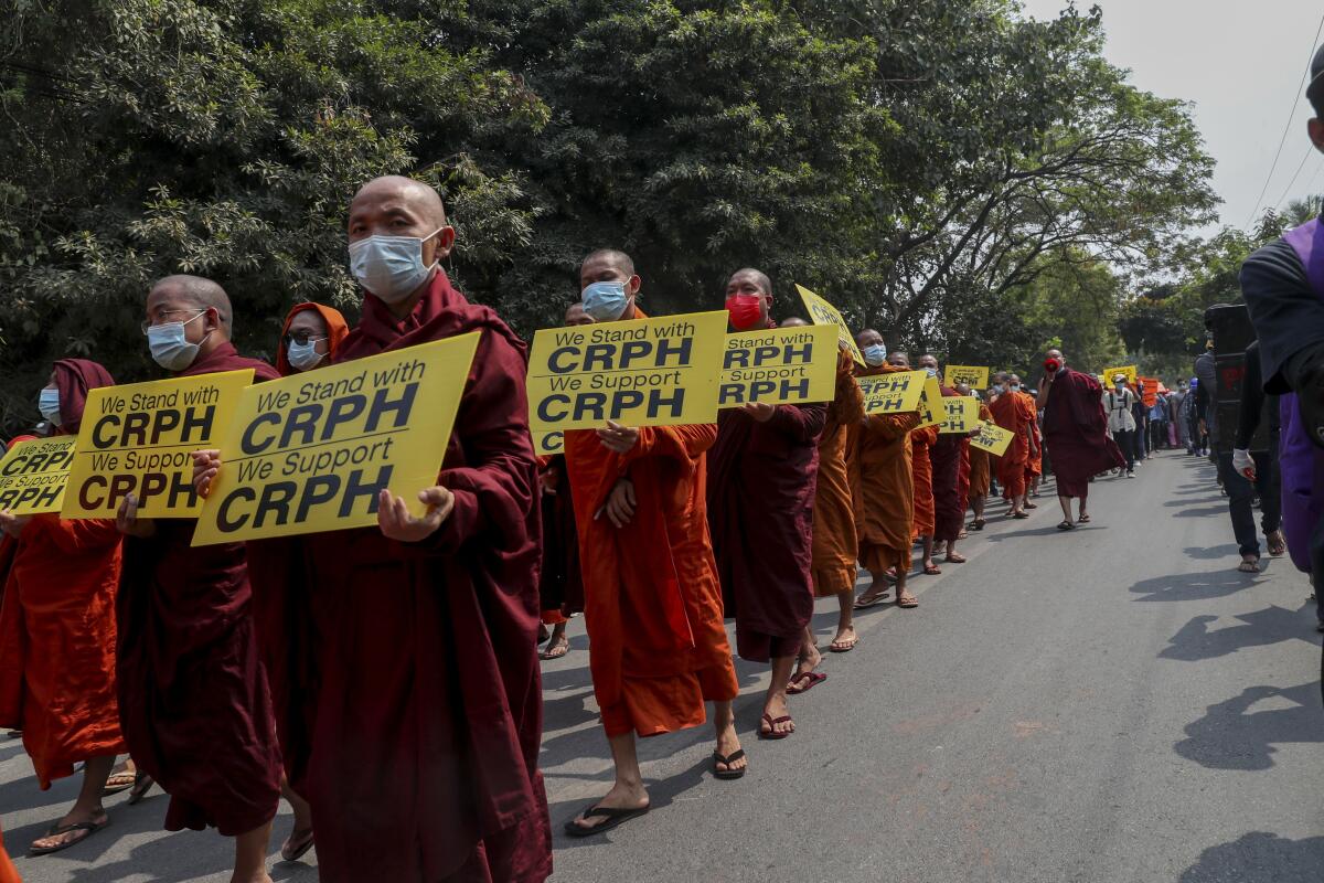 Buddhist monks holding placards march in support of anti-coup protesters 