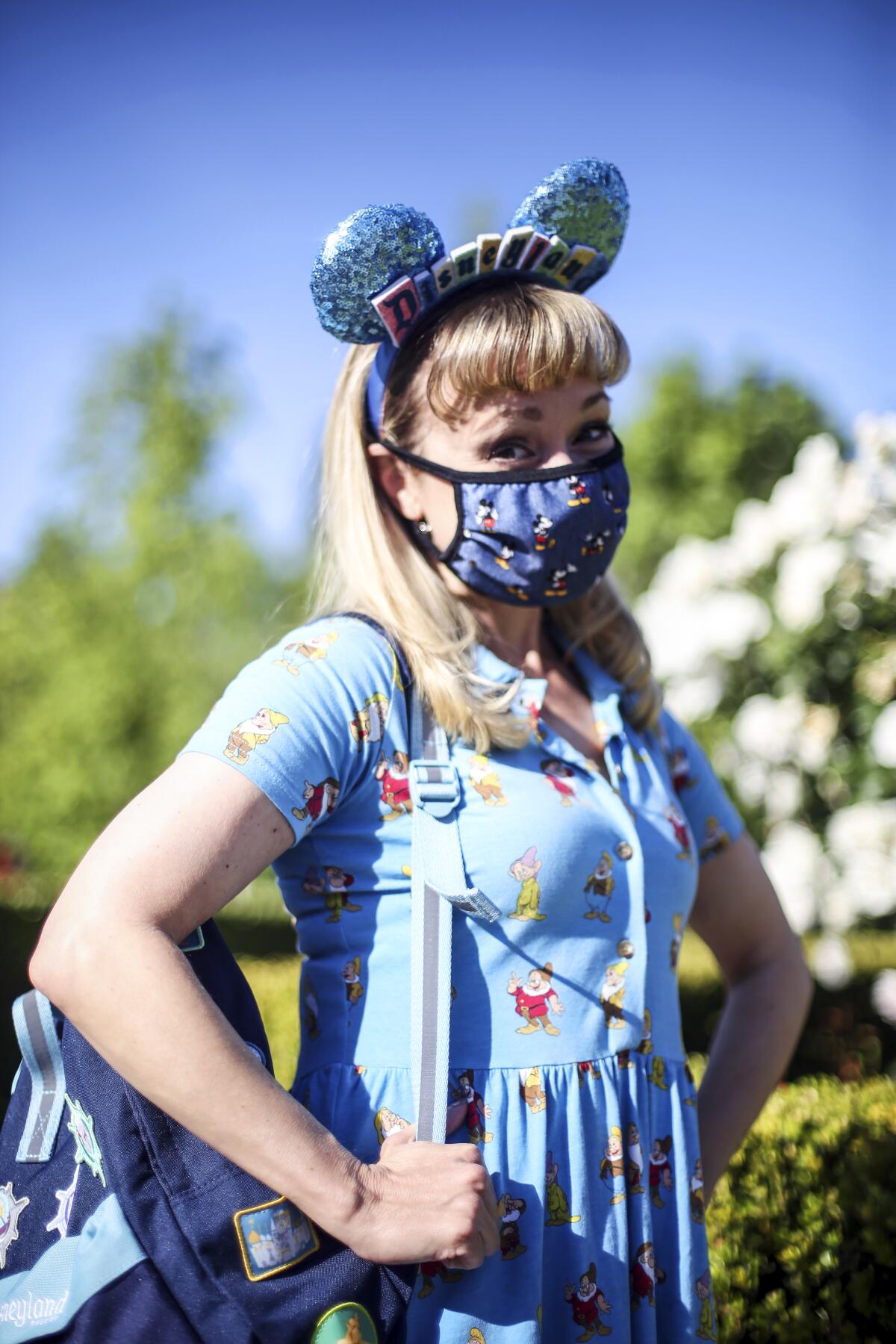 A woman in mouse ears, mask and Seven Dwarfs dress