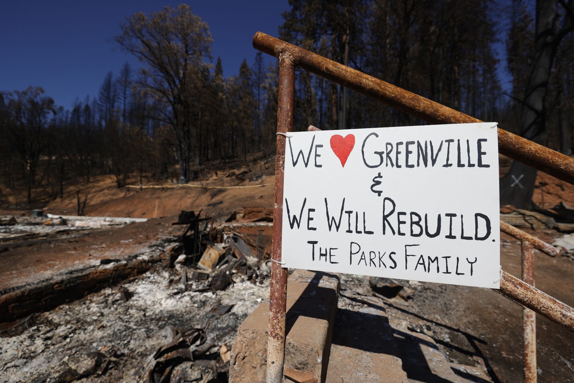 A sign posted outside a home says, "We love Greenville and we will rebuild. The Parks family"