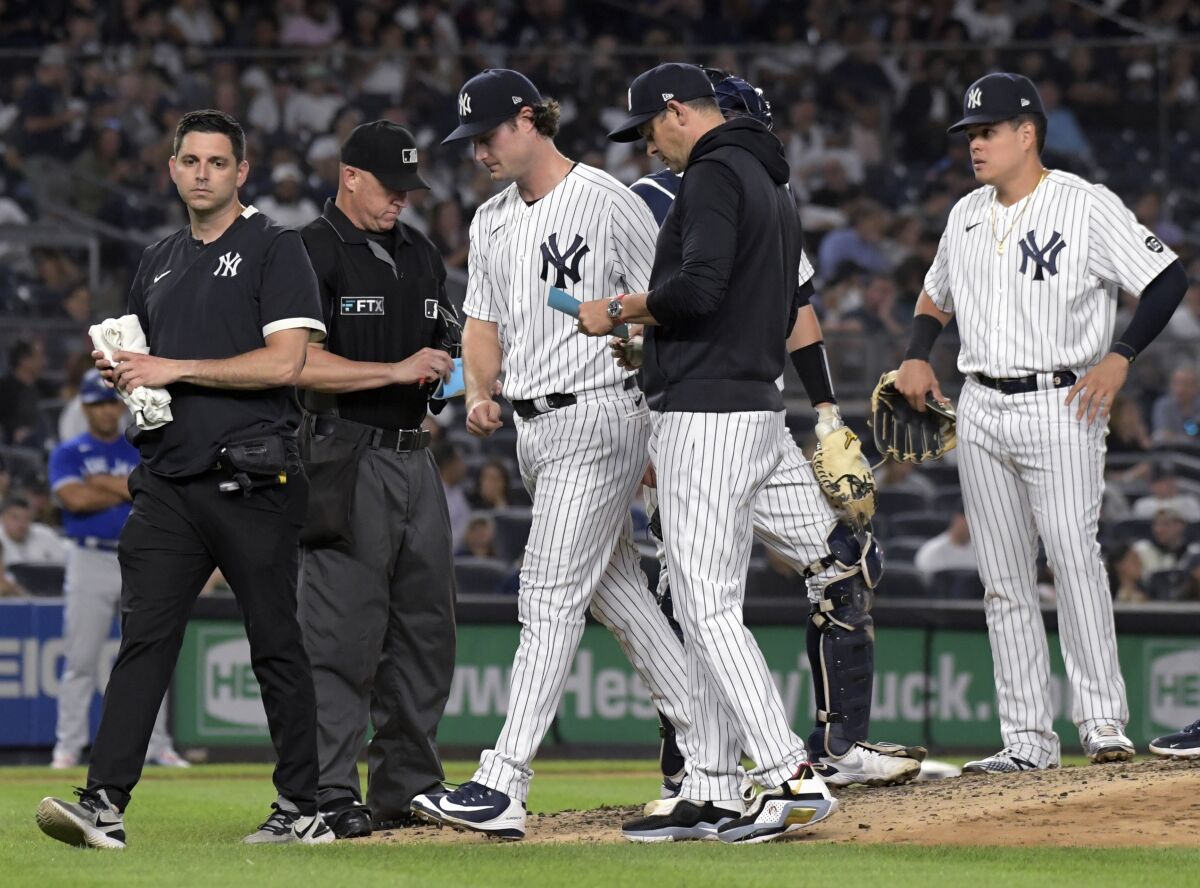 New York Yankees pitcher Gerrit Cole, center, leaves during the fourth inning of the team's baseball game against the Toronto Blue Jays on Tuesday, Sept. 7, 2021, at Yankee Stadium in New York. (AP Photo/Bill Kostroun)