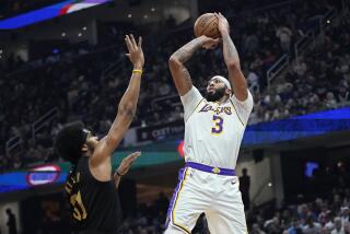 Los Angeles Lakers forward Anthony Davis (3) shoots over Cleveland Cavaliers center Jarrett Allen (31) during the first half of an NBA basketball game Saturday, Nov. 25, 2023, in Cleveland. (AP Photo/Sue Ogrocki)