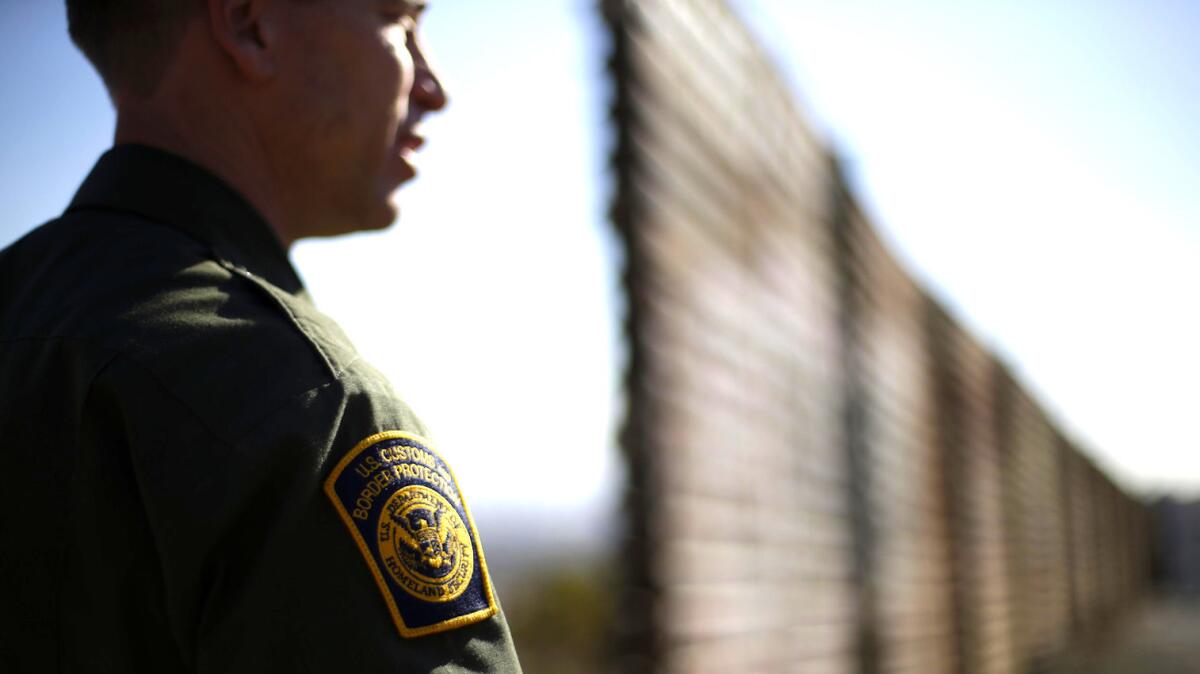 Un agente de la Patrulla Fronteriza vigila desde el muro que divide a Tijuana, Mexico, de San Diego, California.