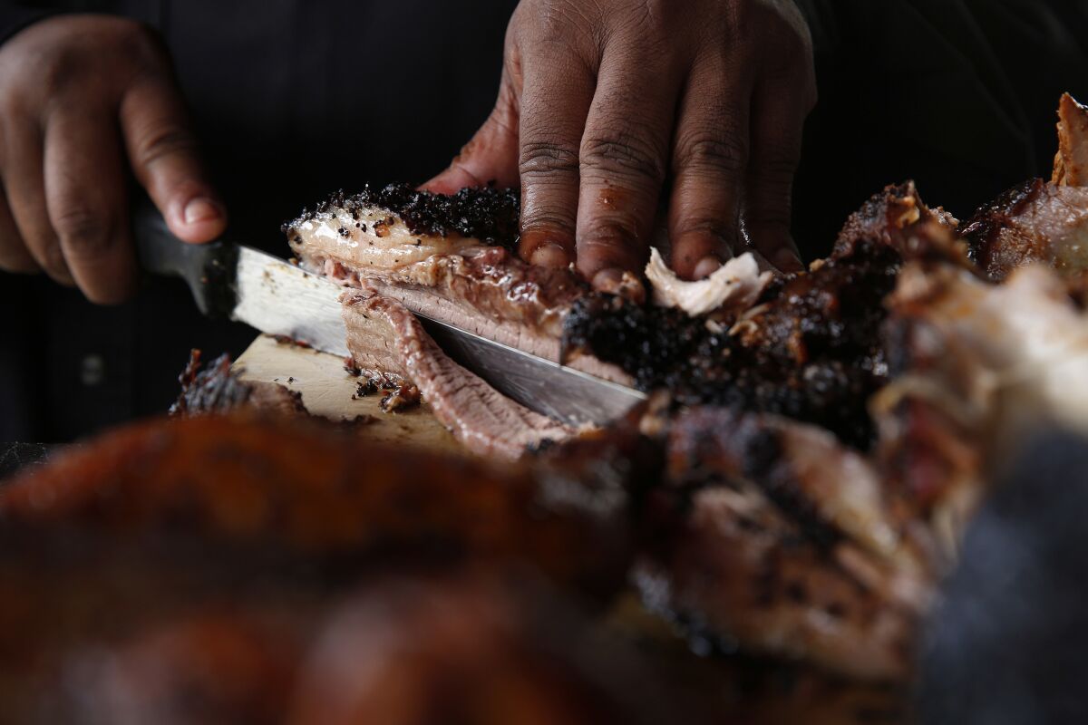 Kevin Bludso cuts barbecued meat at Bludso's BBQ.