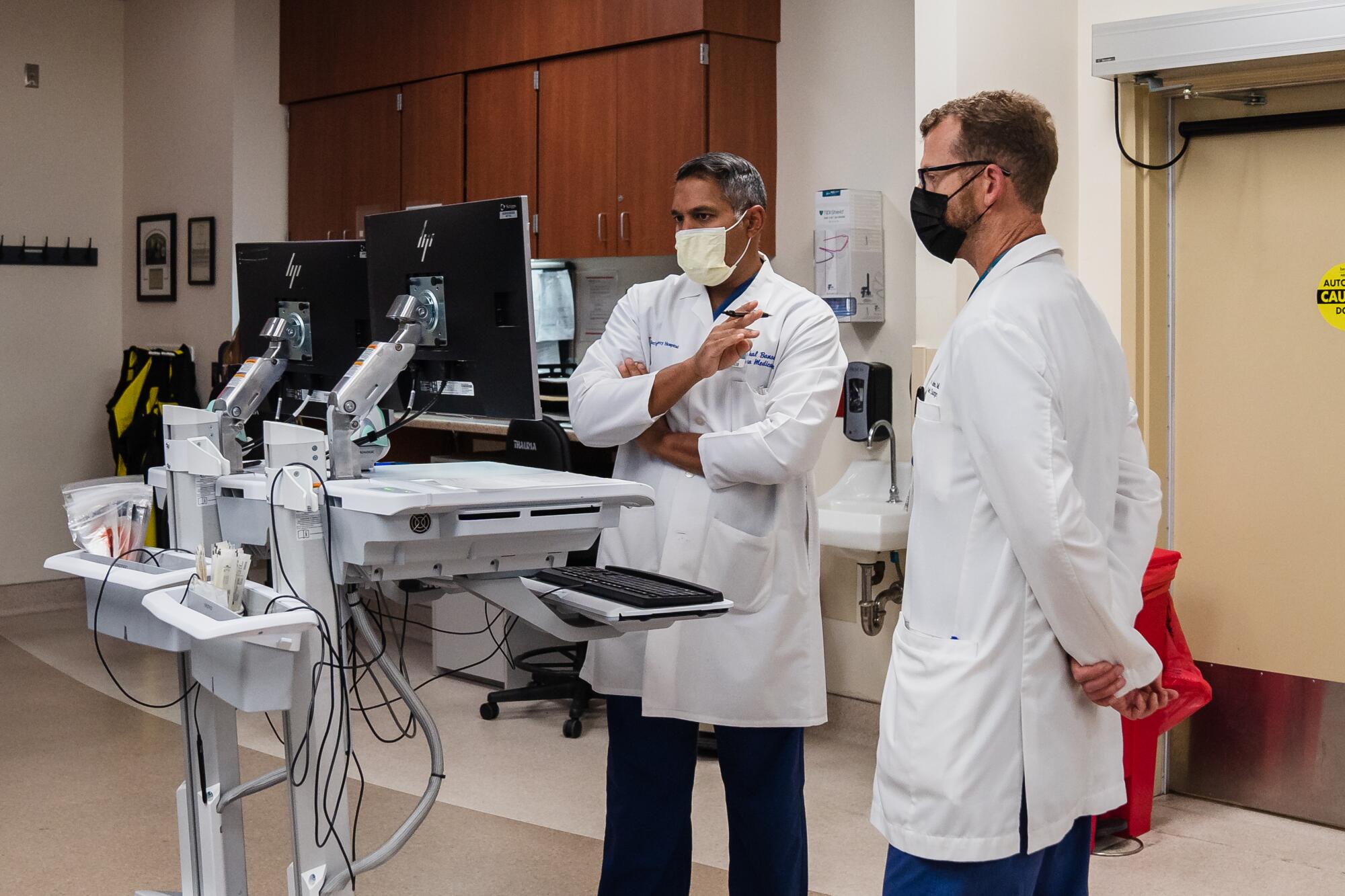 Two doctors look at computers