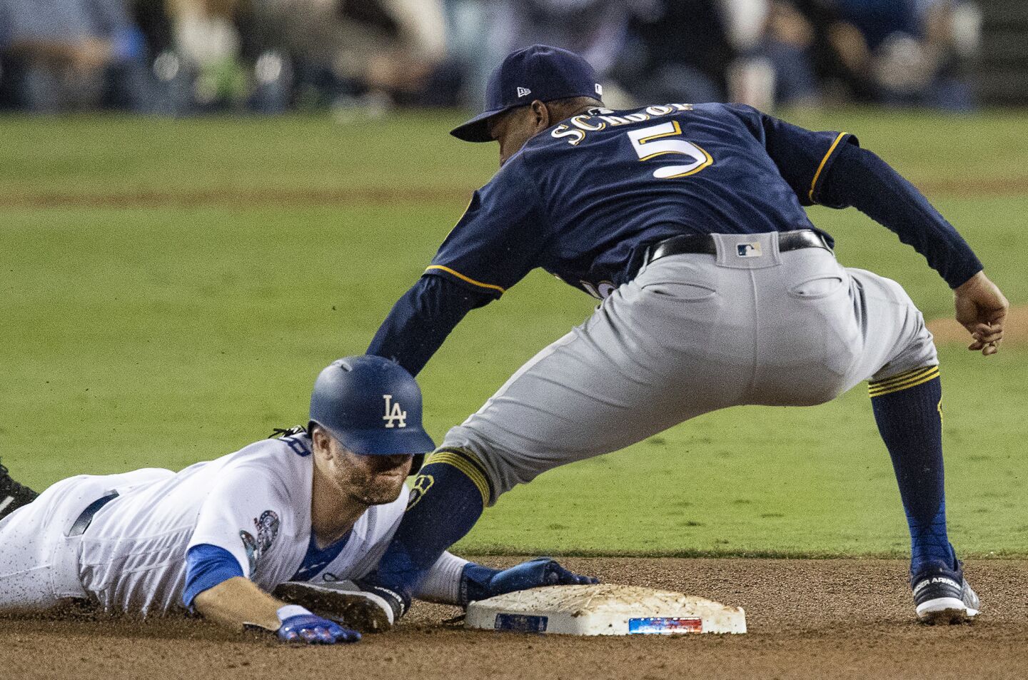 Dodgers Brian Dozier steals second base on a late throw to Milwaukee Brewers second baseman Jonathan Schoop in the third inning.