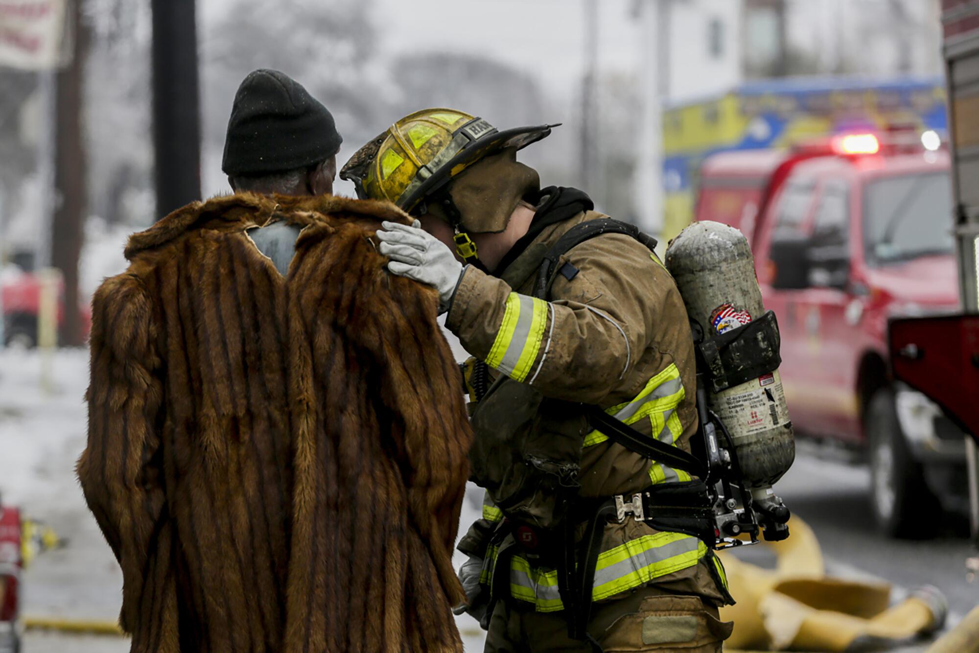 A man and a firefighter on a street. 