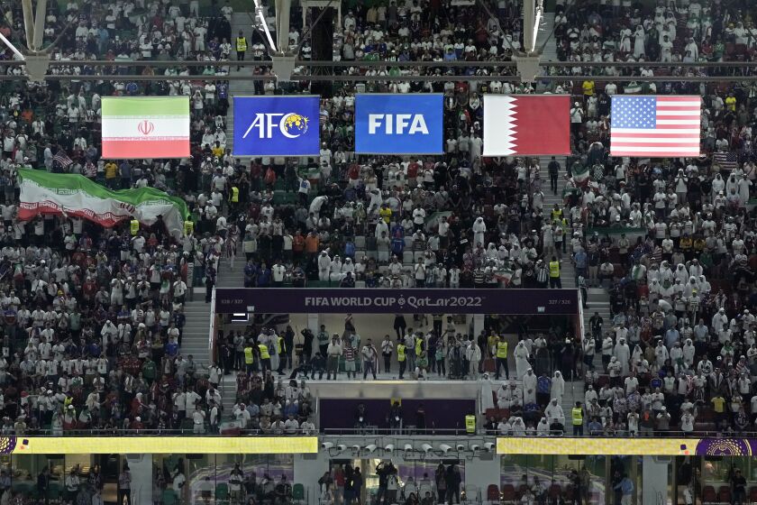 The flags of Iran, left, and the United States, right, hang above the stadium during the World Cup group B soccer match between Iran and the United States at the Al Thumama Stadium in Doha, Qatar, Tuesday, Nov. 29, 2022. (AP Photo/Hassan Ammar)