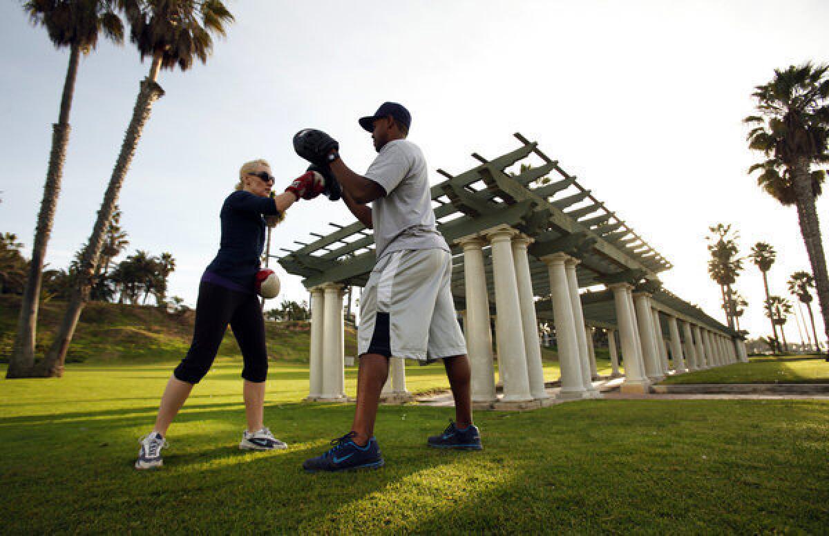 Ruben Lawrence, right, trains Ali Janes during a boxing class at Crescent Bay Park in Santa Monica.