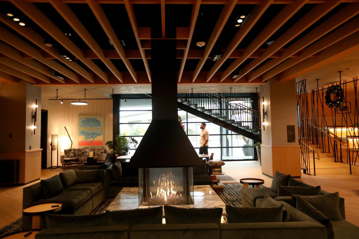 A hotel lobby with a lounge area and a fireplace.