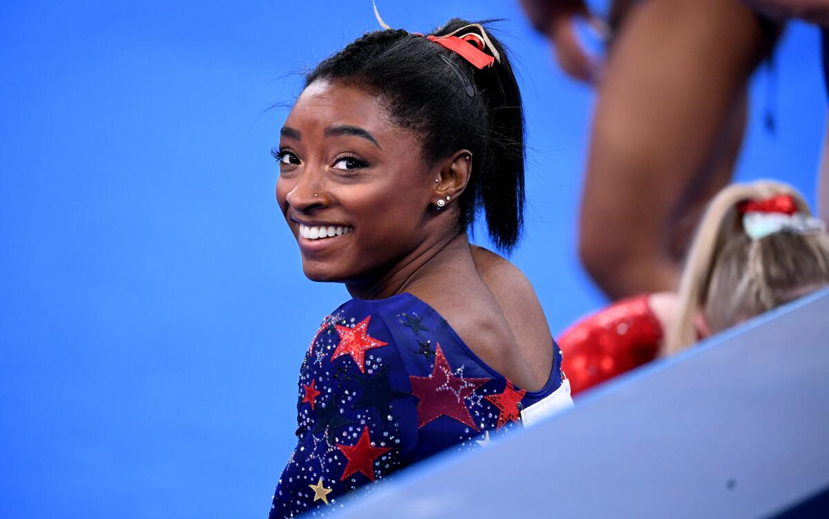 Simone Biles smiles in between sessions in the women's team qualifying at the 2020 Tokyo Olympics.