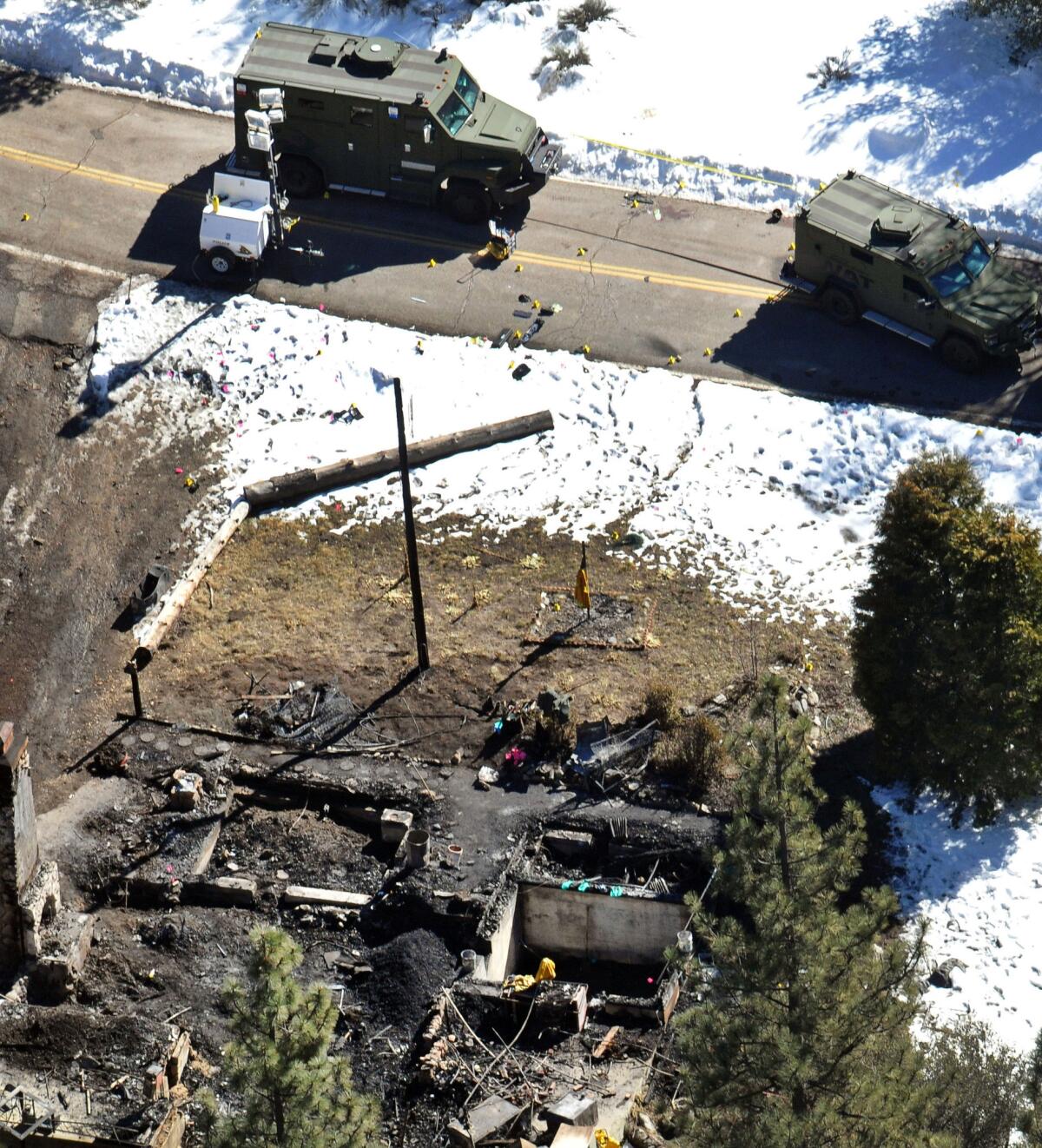 In this Feb. 13, 2013, aerial file photo, law enforcement authorities investigate the burnt-out cabin where quadruple-murder suspect Christopher Dorner died after barricading himself inside during a standoff with police in the Angeles Oaks area of Big Bear.